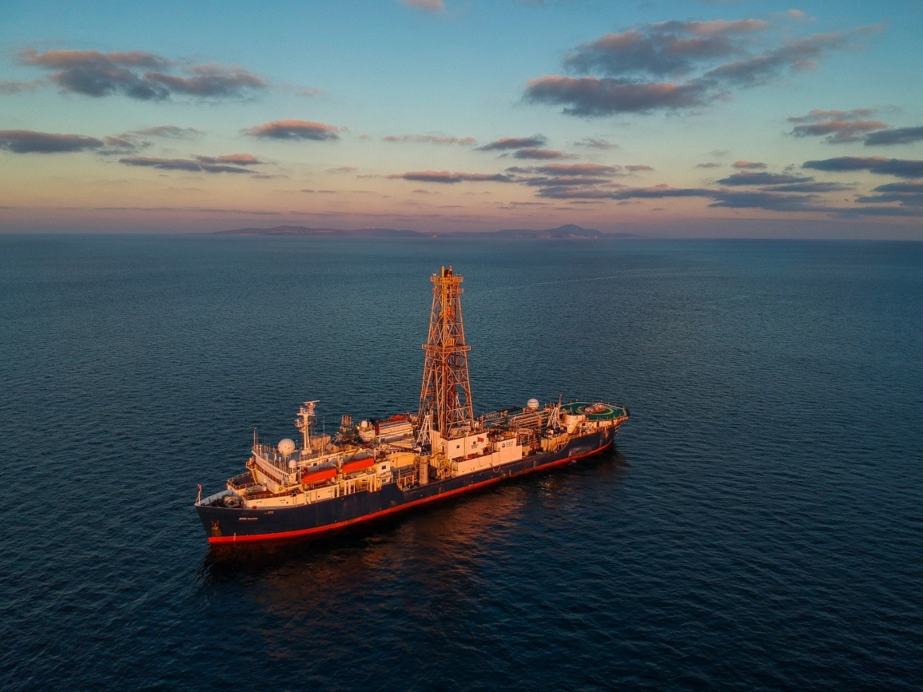 Figure 1 . Le navire JOIDES Resolution au nord du Volcan de Santorin (au loin dans la photo). L��Exp��dition 398 a dur�� deux mois (11 d��cembre 2022 au 10 janvier 2023). Photo courtesy of Thomas Ronge.